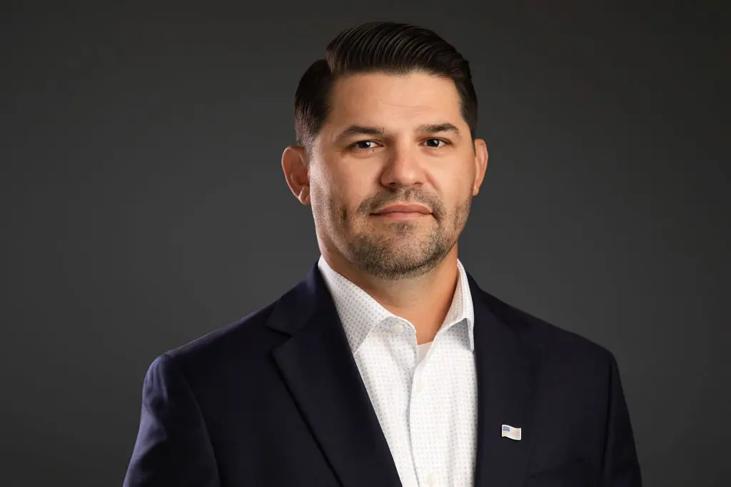 Professional man in a suit against dark background.