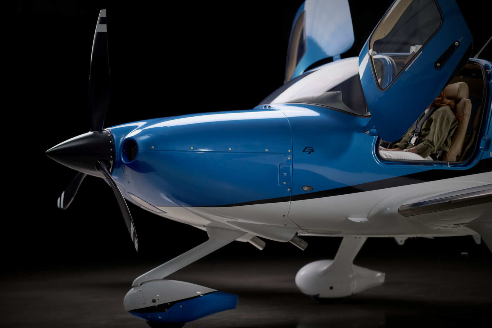 Blue aircraft with open cockpit door.